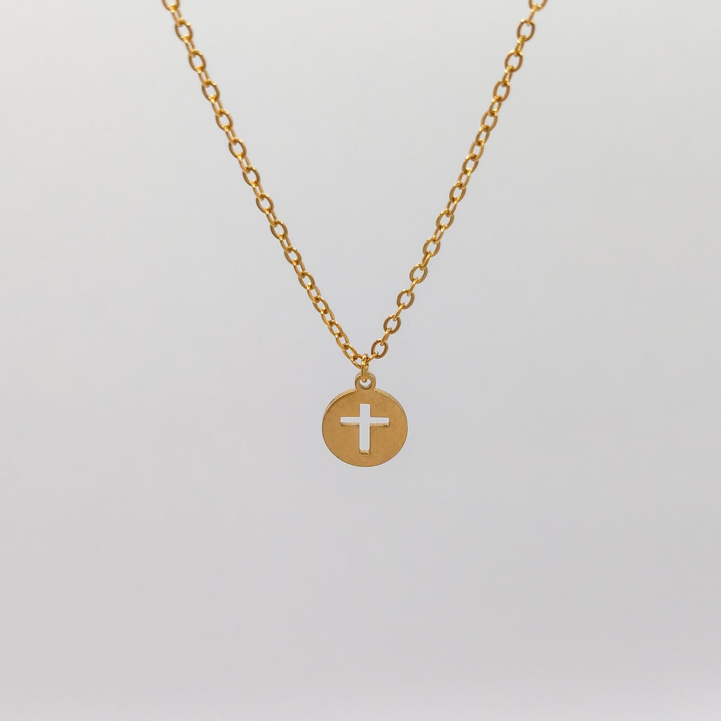 packshot of a gold plated cross disk necklace that is waterproof and tarnish resistant