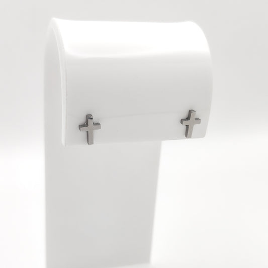 Pair of silver-plated cross stud earrings on a white display stand.