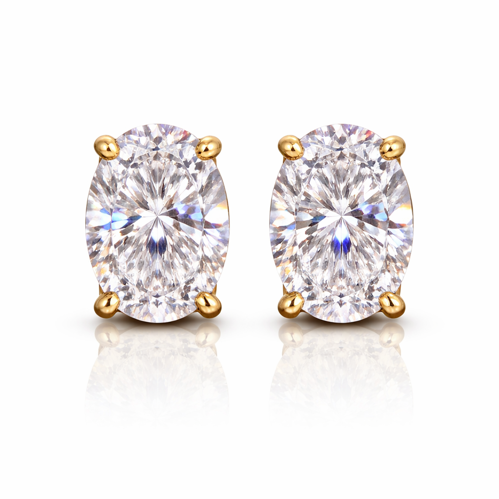 Pair of gold-plated earrings with clear oval cubic zirconia's on a white background