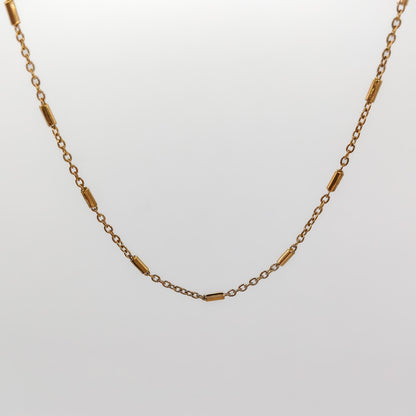 A close-up view of the gold-plated bar and link chain, showcasing the smooth texture of the polished 2mm station bars.
