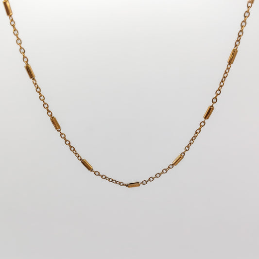 A close-up view of the gold-plated bar and link chain, showcasing the smooth texture of the polished 2mm station bars.