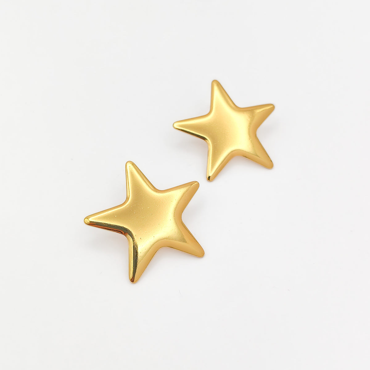 A pair of gold star-shaped stud earrings on a clean white background.
