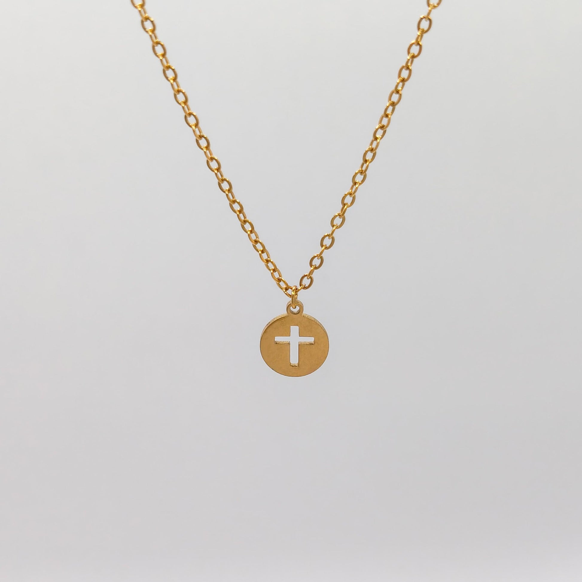 packshot of a gold plated cross disk necklace that is waterproof and tarnish resistant