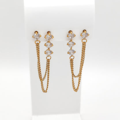 Front view of gold-plated double-hole chain earrings with clear cubic zirconia studs on a white stand.