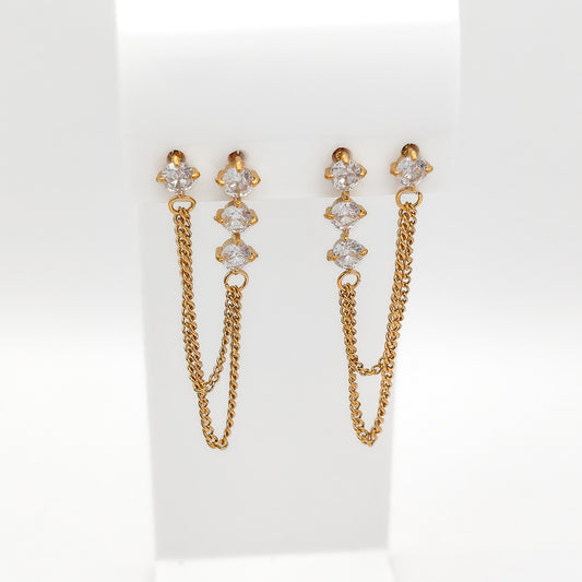 Front view of gold-plated double-hole chain earrings with clear cubic zirconia studs on a white stand.