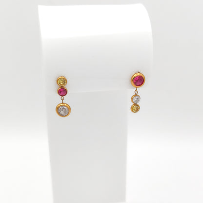 Gold-plated stainless steel mismatch bezel-set drop earrings with pink, yellow, and clear round cubic zirconia stones on a white stand.