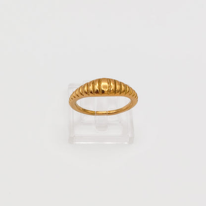 Close-up of the gold-plated ribbed dome ring on a clear acrylic stand, showcasing the polished vertical ridges.