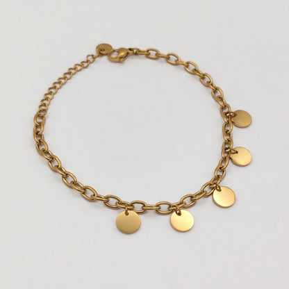 packshot of a gold plated round disk bracelet that is waterproof and tarnish resistant