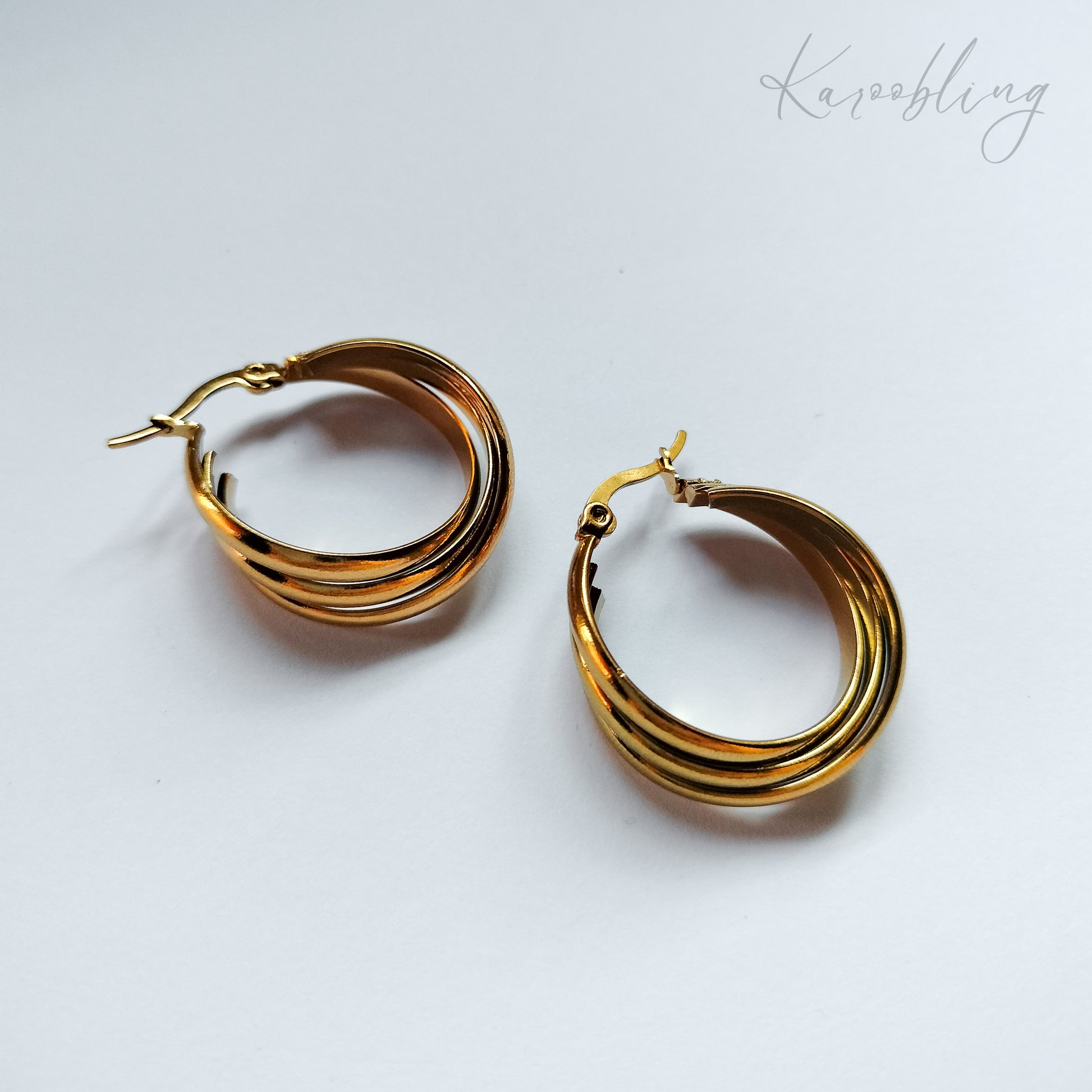 packshot of gold plated triple twisted hoop earrings that is waterproof and tarnish resistant