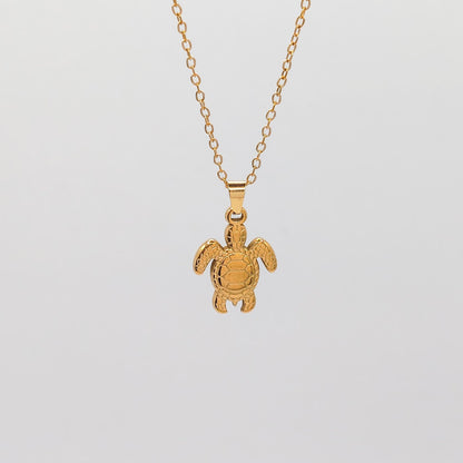 packshot of a gold plated sea turtle pendant necklace that is waterproof and tarnish resistant