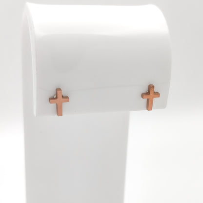 Close-up of rose gold-plated cross stud earrings showing the simple cross design.
