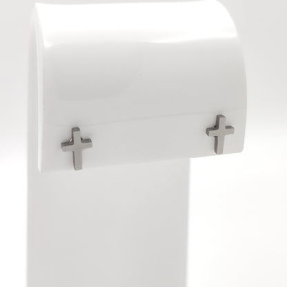 Close-up of silver-plated cross stud earrings showing the simple cross design.