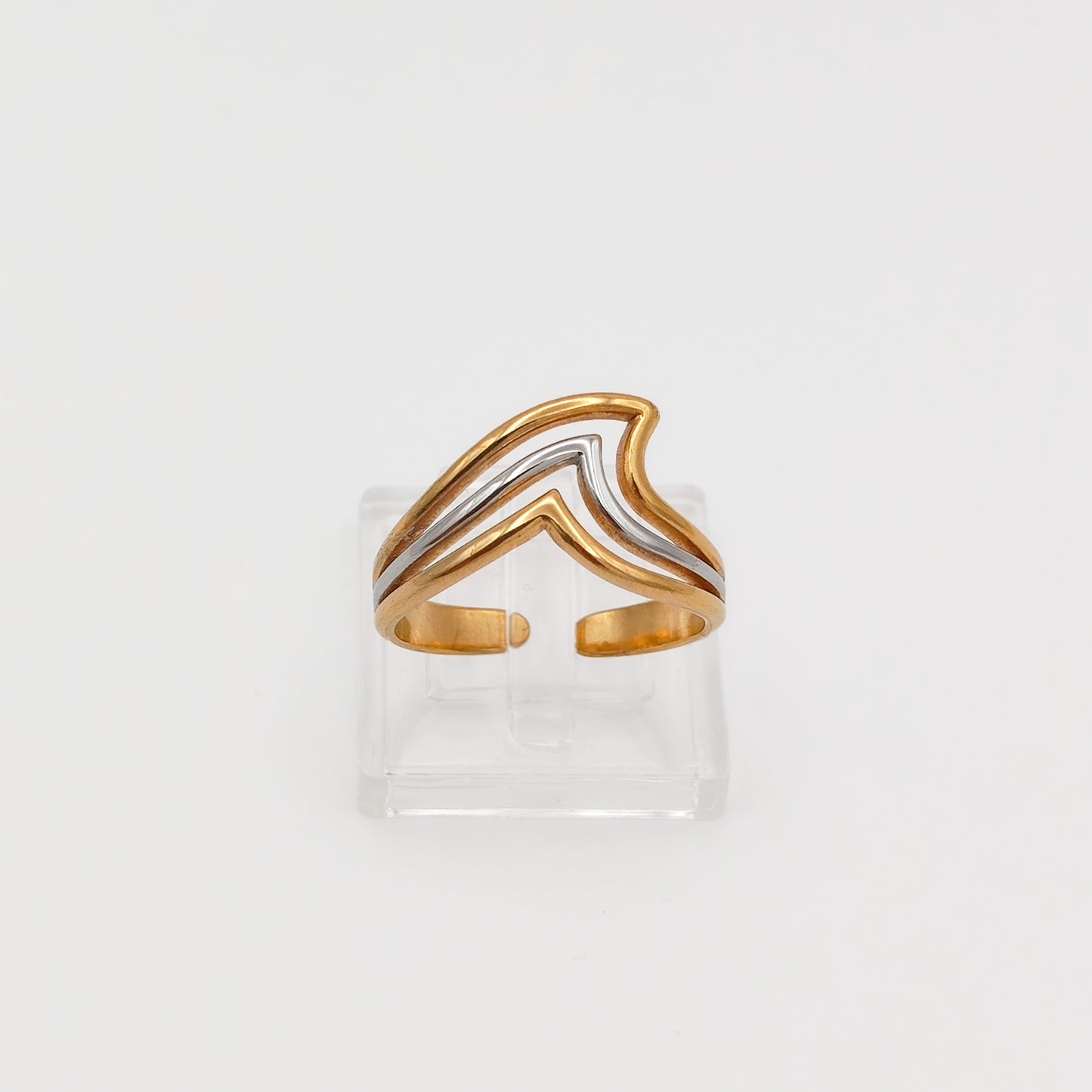 Front view of the gold and silver layered chevron wave ring on a clear acrylic stand, showcasing the open-back adjustable band.