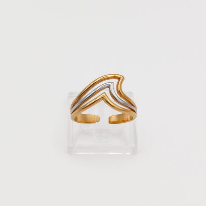 Front view of the gold and silver layered chevron wave ring on a clear acrylic stand, showcasing the open-back adjustable band.