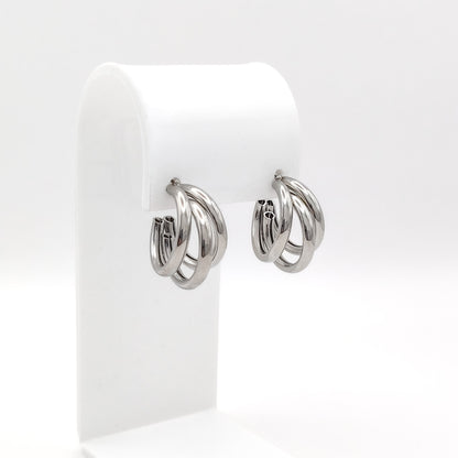 Pair of silver hoop earrings on a white display stand