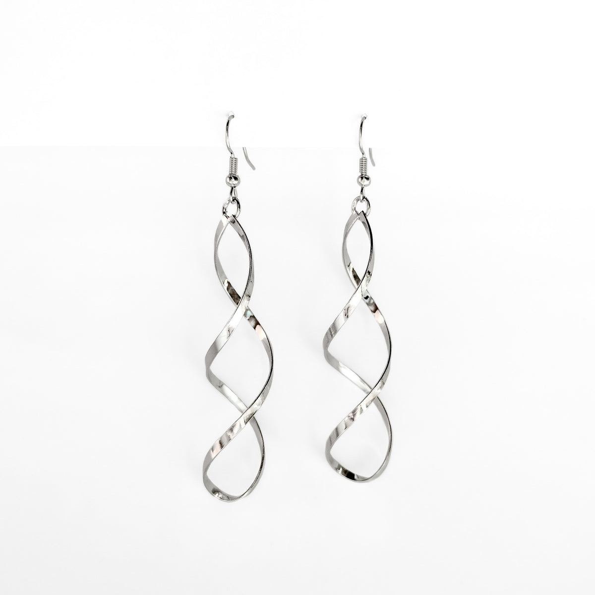 silver plated spiral dangle earrings on a white display stand