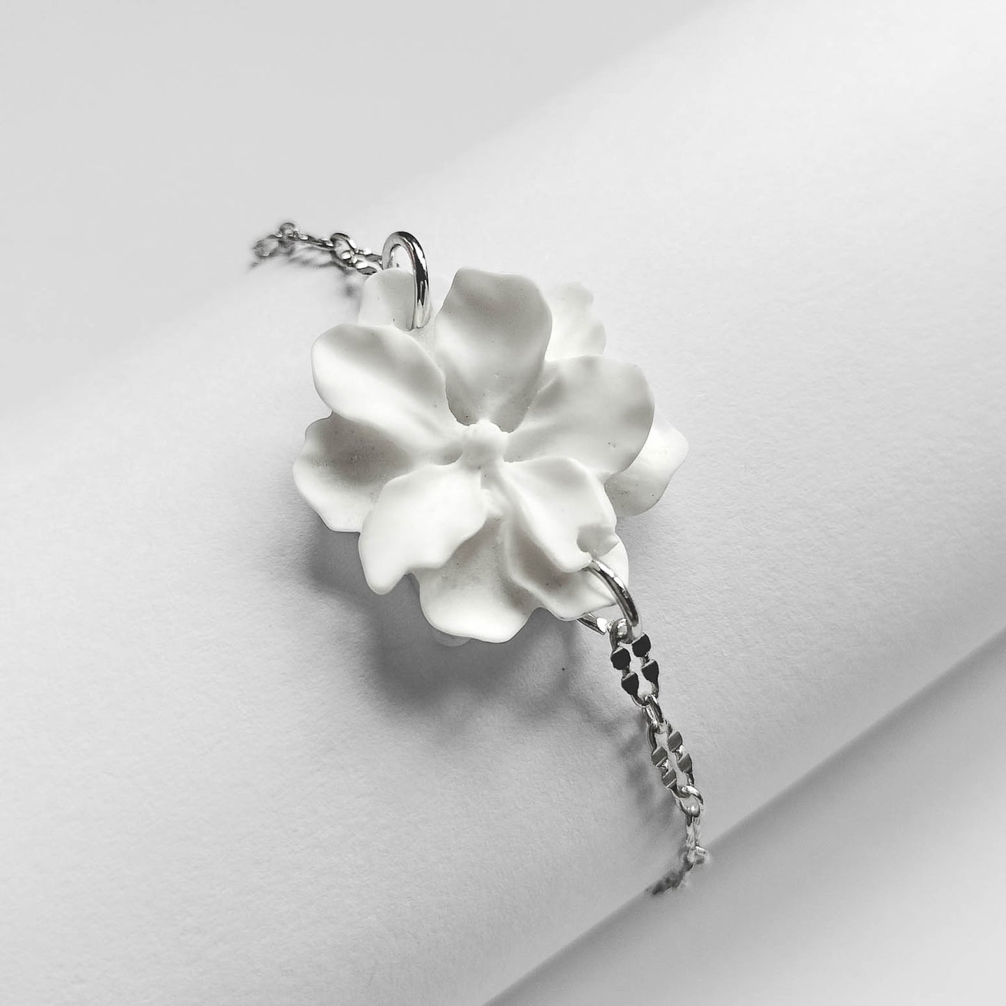 packshot of a fashion jewellery silver plated white resin flower statement bracelet
